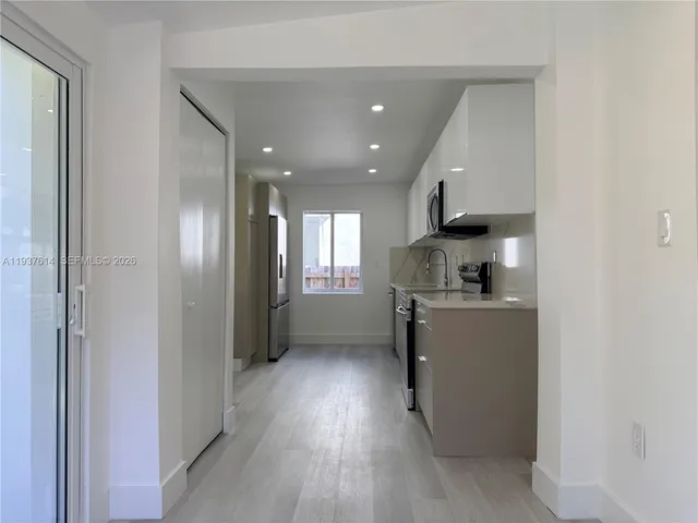 a kitchen with a refrigerator and a stove top oven