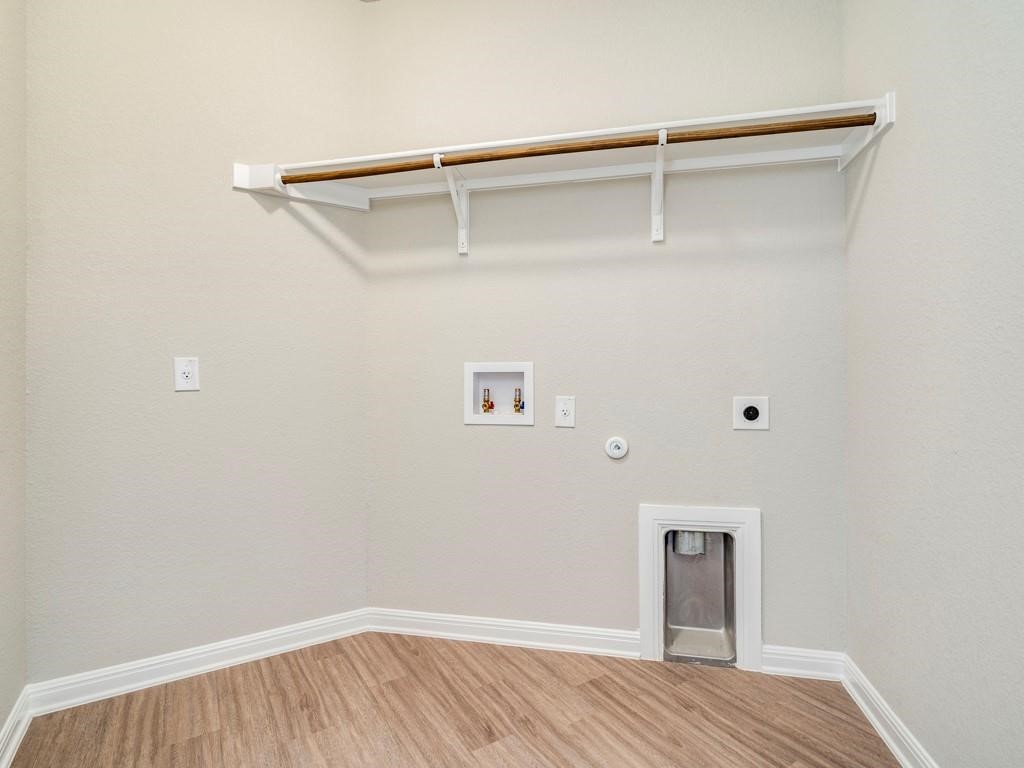 4210 Birdwatch Loop, Unit 2 Pflugerville, TX 78660 - Photo 23 of 31 A well-appointed utility area featuring wood-look flooring and convenient overhead shelving.