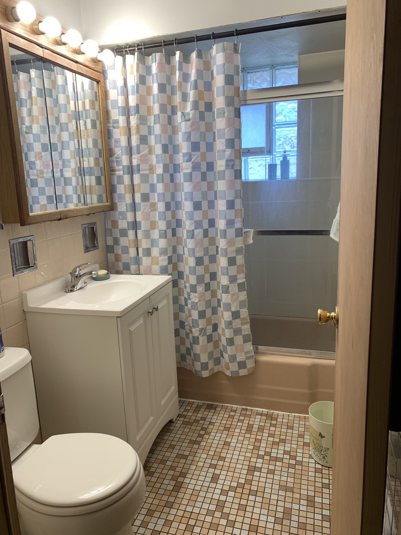 5706 St Charles Road Berkeley, IL 60163 - Photo 15 of 20 a bathroom with a sink a toilet a window and shower