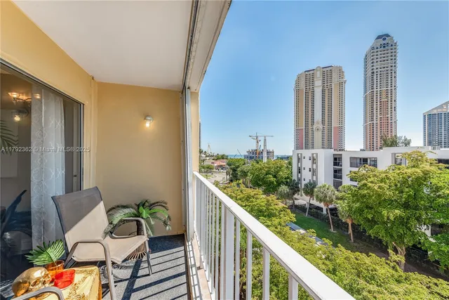 a balcony with chairs and table of wooden floor