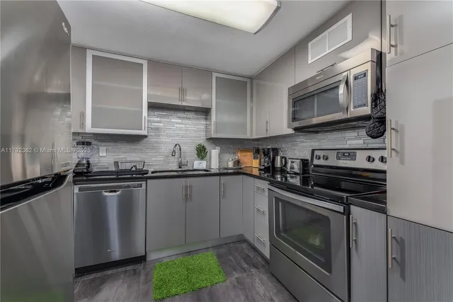 a kitchen with stainless steel appliances granite countertop a stove microwave and sink