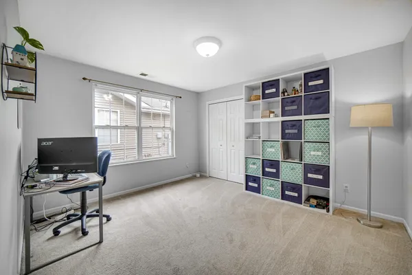 a view of a bedroom with workspace and window