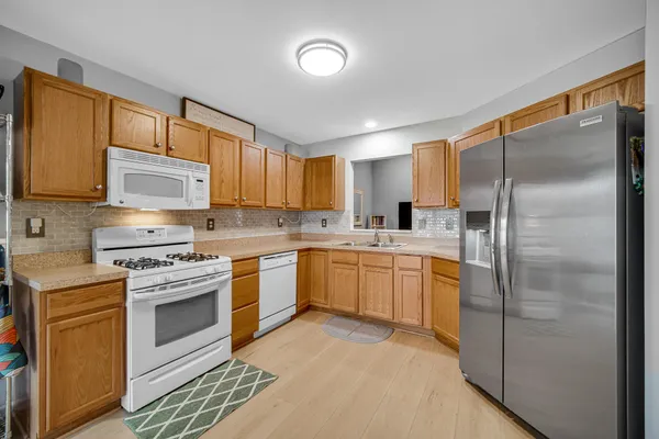 a kitchen with a refrigerator sink and cabinets