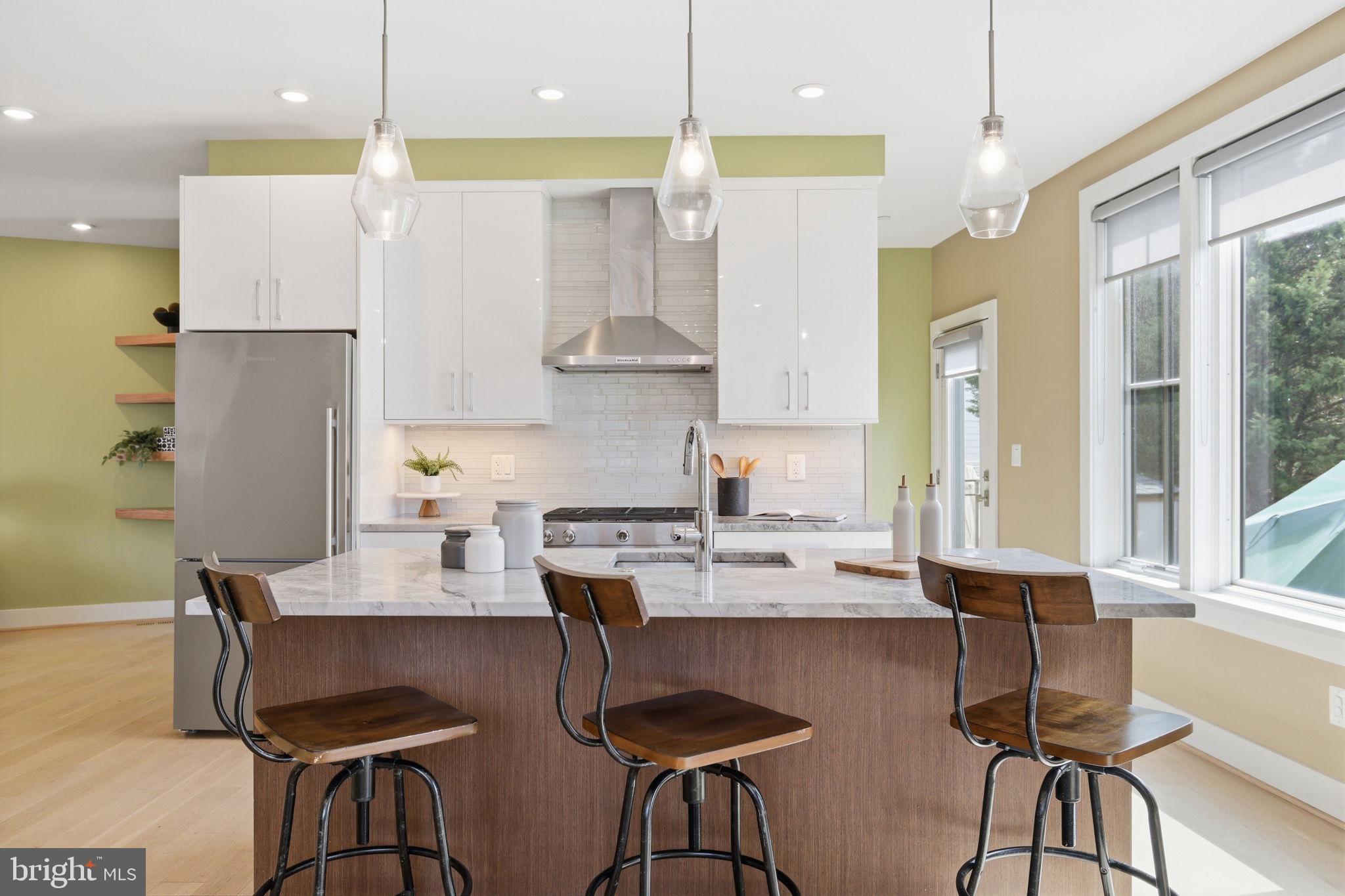 1301 Potomac Avenue Southeast, Unit 2 Washington, DC 20003 - Photo 2 of 30 a kitchen with stainless steel appliances granite countertop a stove a refrigerator a kitchen island a dining table and chairs