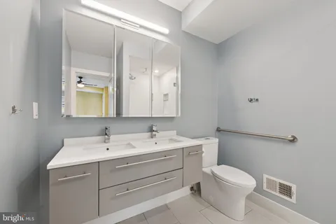 a bathroom with a sink a toilet and a mirror