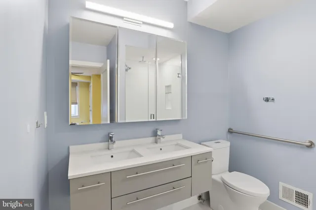 a bathroom with a toilet a sink a mirror and a shower