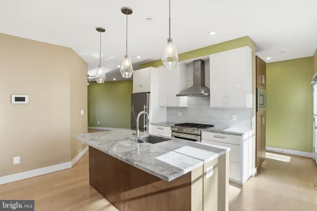 a kitchen with stainless steel appliances granite countertop a sink a stove and a refrigerator