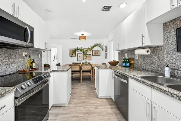 a kitchen with stainless steel appliances granite countertop a sink stove microwave and cabinets