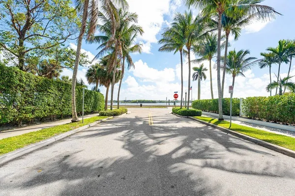a view of a house with a yard and palm trees