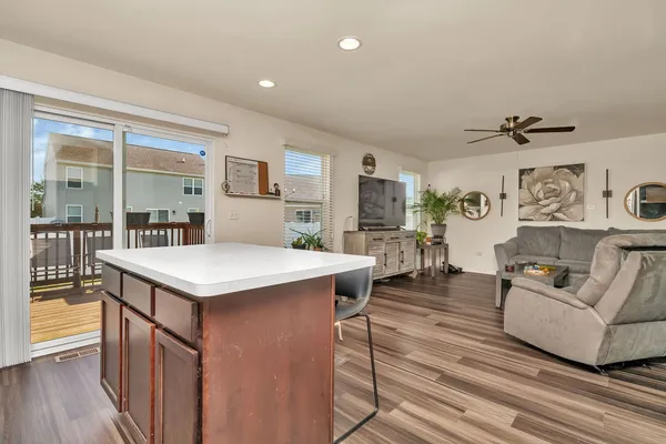a living room with stainless steel appliances kitchen island granite countertop a table and chairs in it