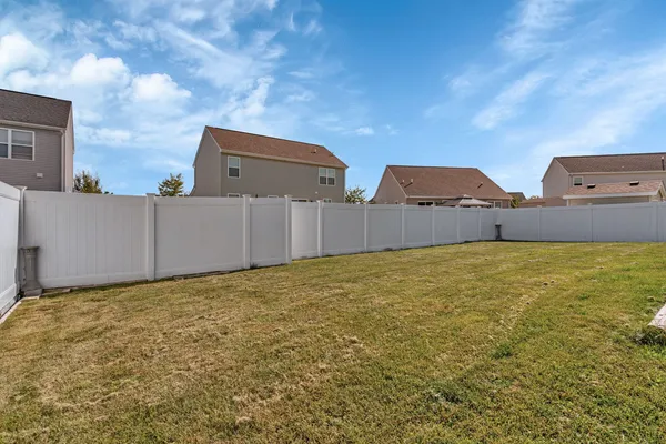 a view of a large house with a yard and wooden fence