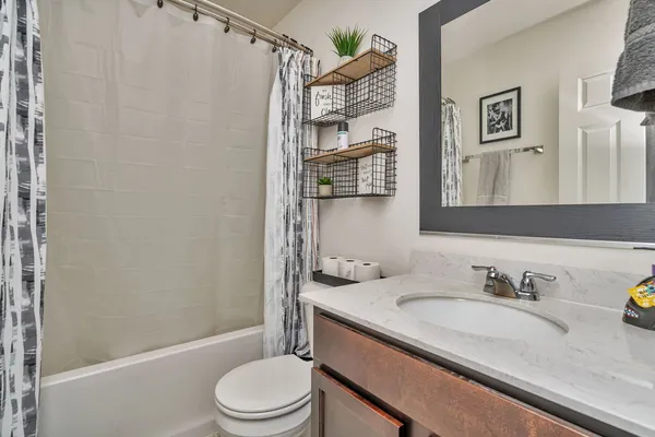 a bathroom with a granite countertop sink toilet and shower
