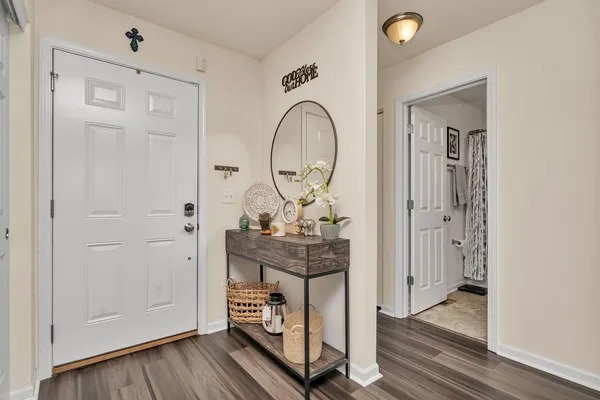 a view of a hallway with entryway wooden floor and front door