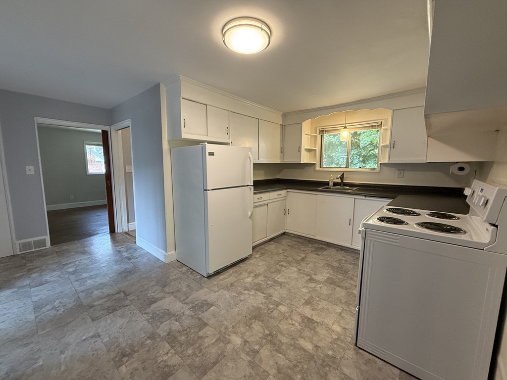 36 5th Avenue Lowell, MA 01854 - Photo 6 of 16 a kitchen with a refrigerator sink and stove