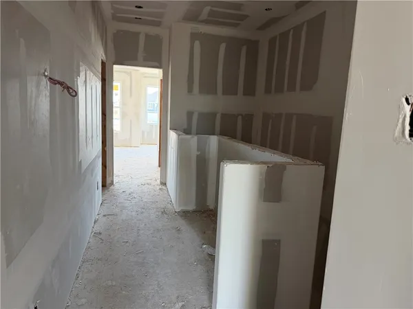 a view of a refrigerator in kitchen and an empty room