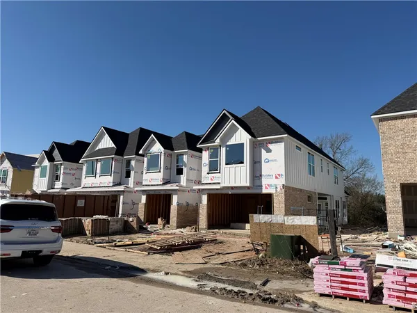 a front view of a house with cars park