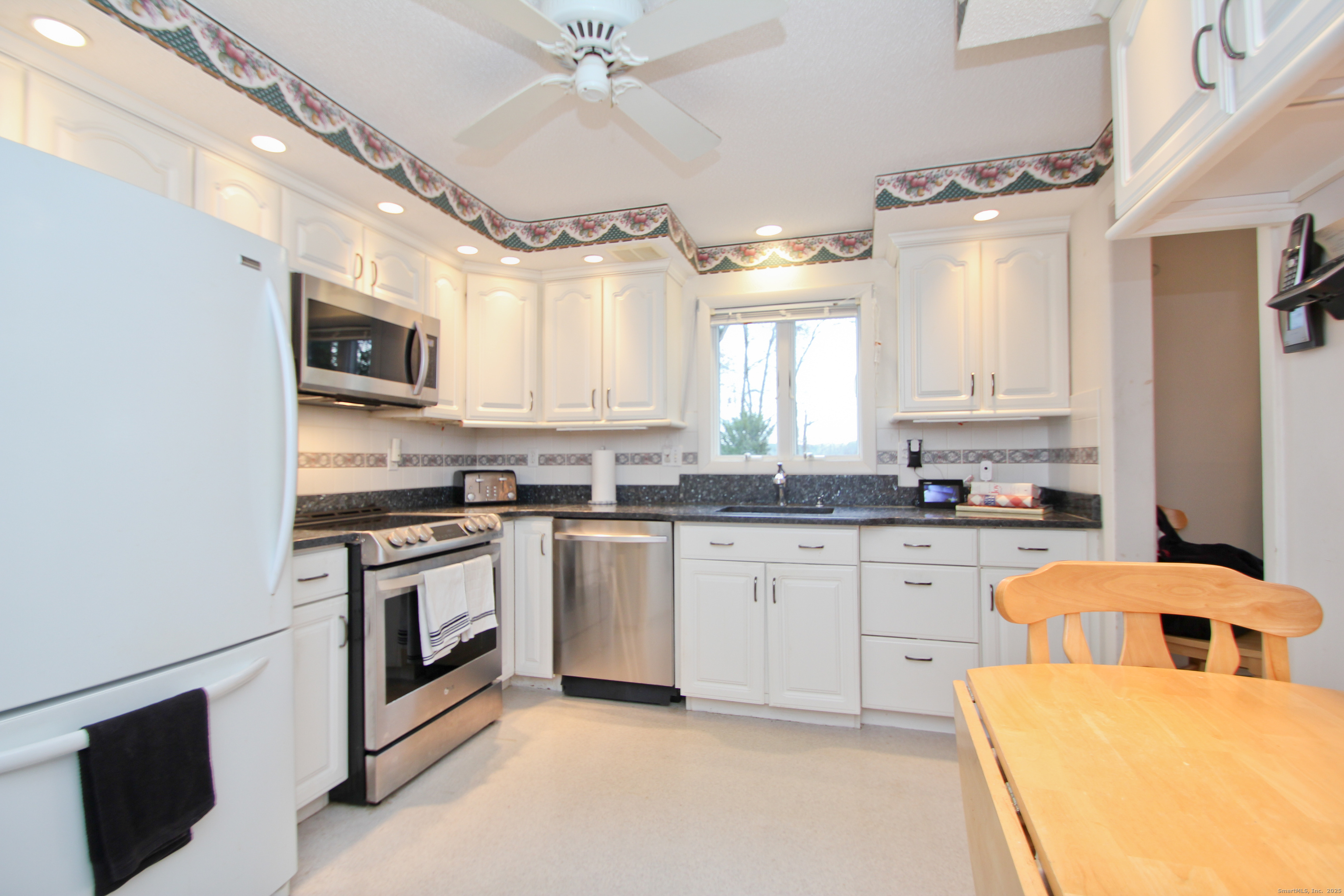 11 Northfield Road Enfield, CT 06082 - Photo 12 of 34 a kitchen with stainless steel appliances granite countertop a stove top oven a sink a counter space and cabinets