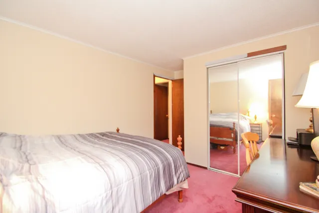 a spacious bedroom with a bed and large windows