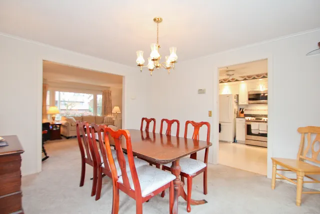 a dining room with furniture a chandelier and window