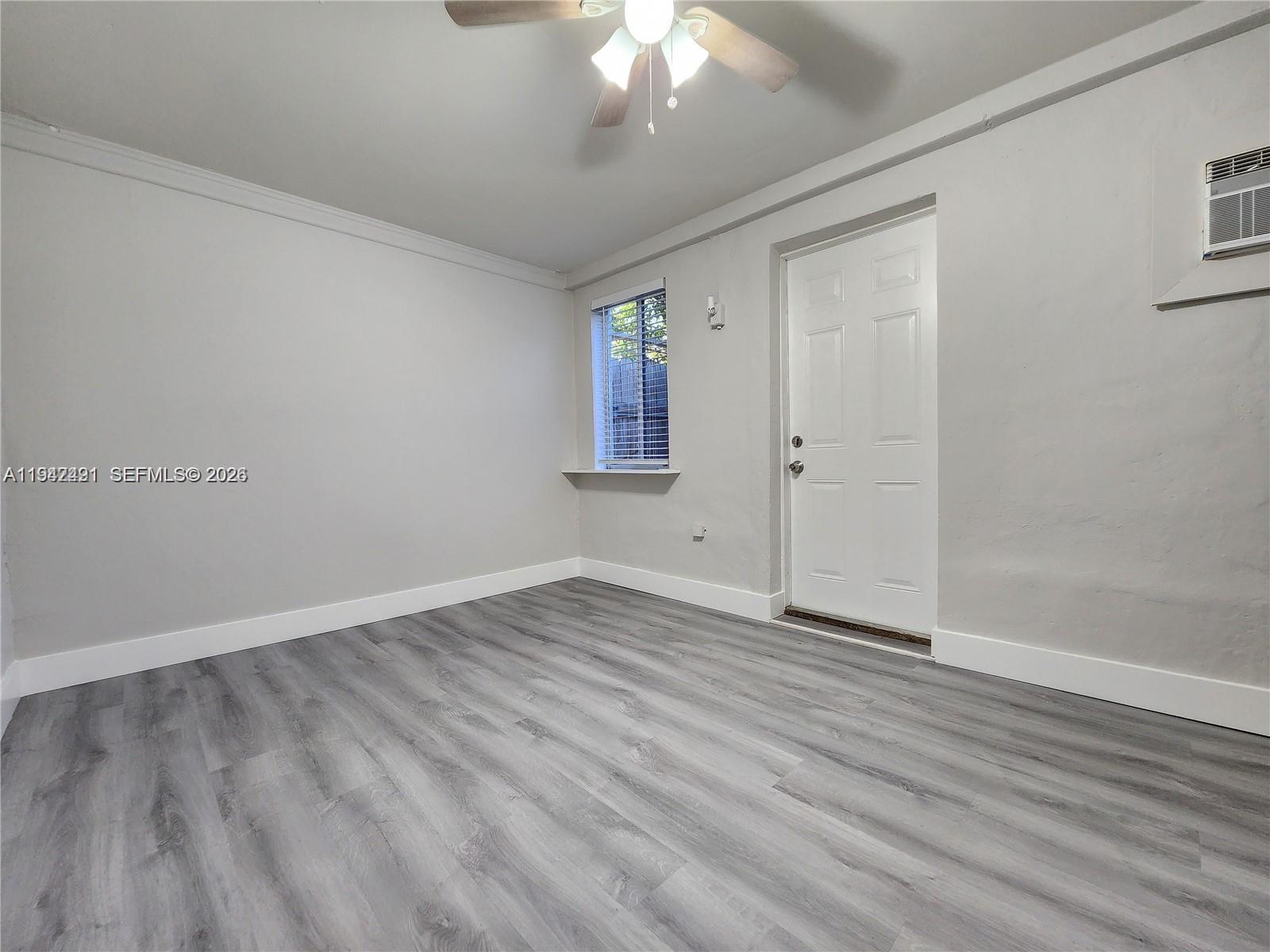 8295 Northeast 3rd Avenue, Unit 3 Miami, FL 33138 - Photo 3 of 7 a view of an empty room with wooden floor and a window