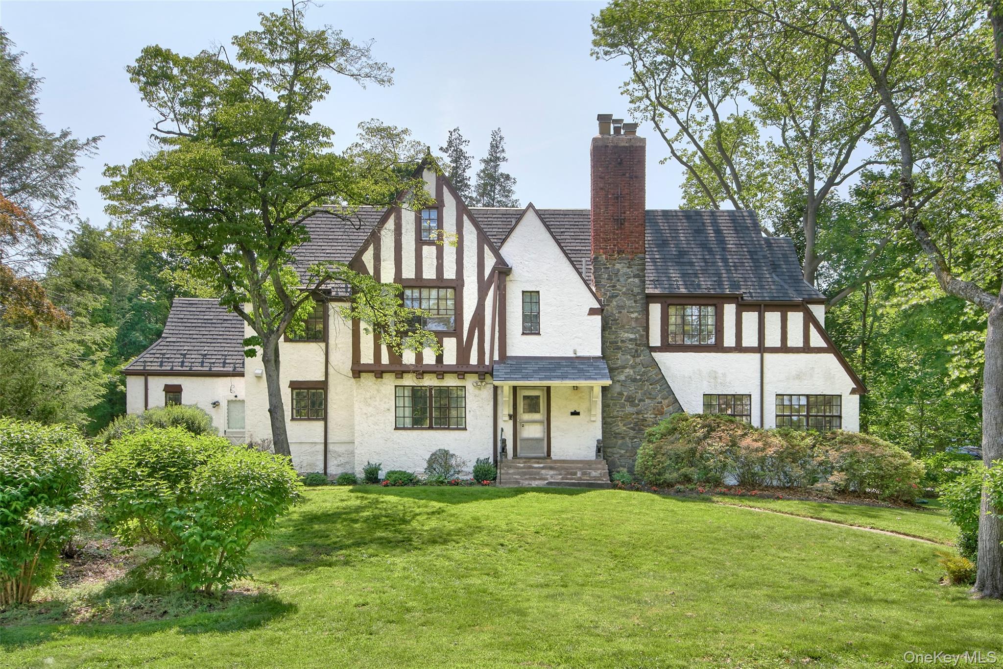 2 Byworth Road New Rochelle, NY 10804 - Photo 1 of 31 Tudor house with stucco siding, a chimney, a front lawn, and stone siding