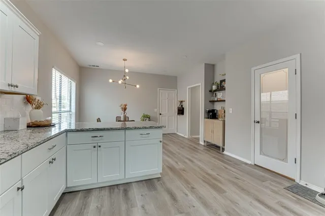 a spacious bathroom with a granite countertop sink and a mirror