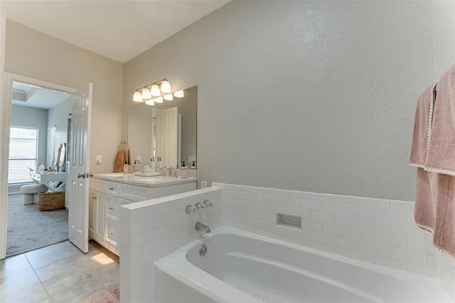 a spacious bathroom with a bathtub and a sink