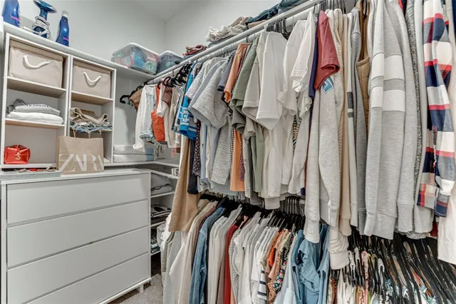 a view of walk in closet with clothes and shoes