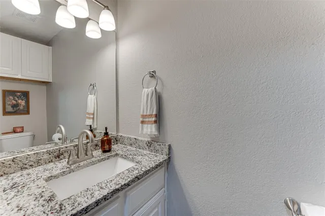 a bathroom with a granite countertop sink and a mirror