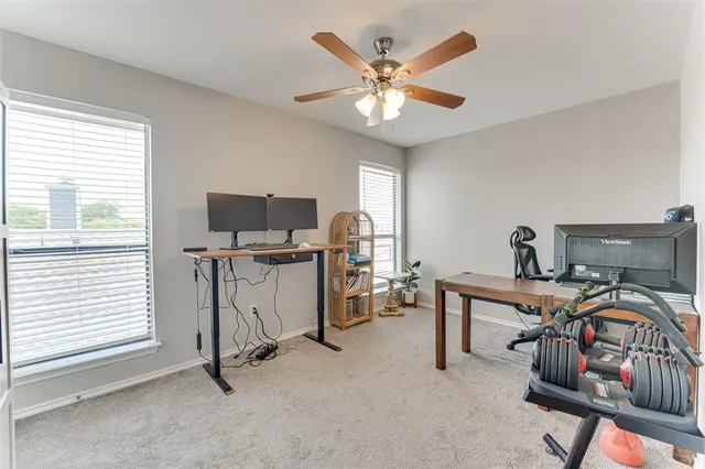 a view of a workspace with furniture and a window