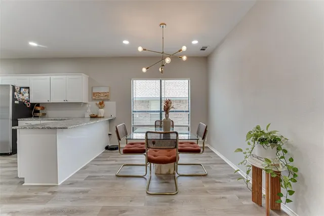 a kitchen with living room and white cabinets