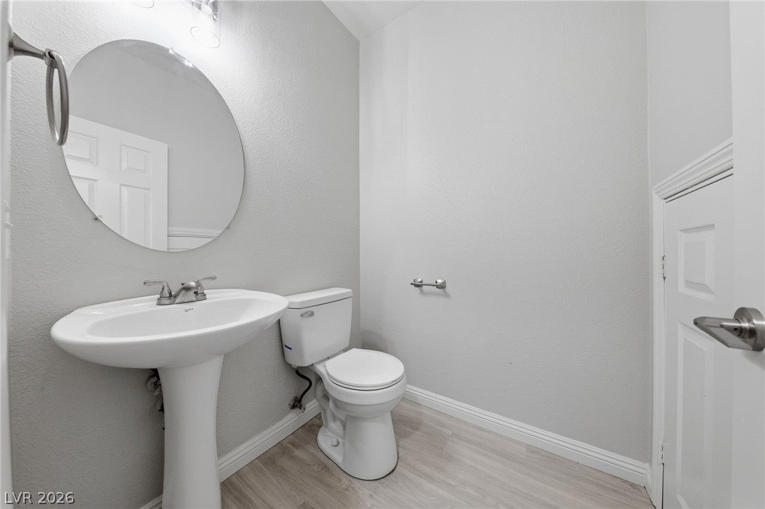 6312 Sandy Ridge Street, Unit 3102 North Las Vegas, NV 89081 - Photo 12 of 31 A well-lit powder room offers contemporary fixtures and light wood-look flooring.