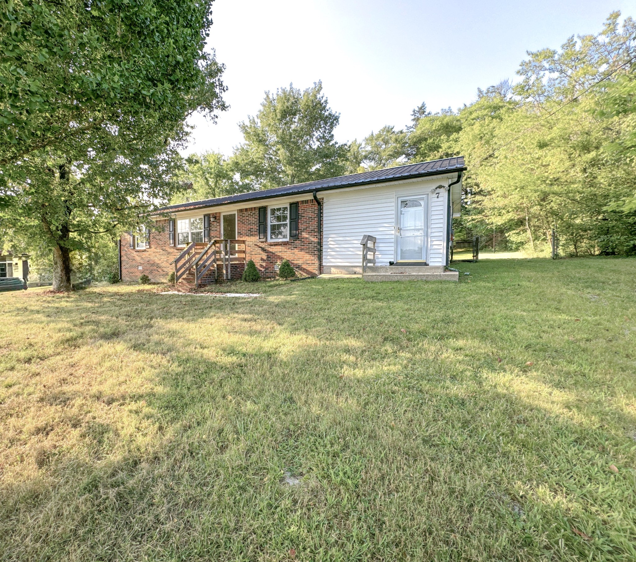 7 Switchboard Road Brush Creek, TN 38547 - Photo 2 of 20 a view of a yard in front of a house with a large tree