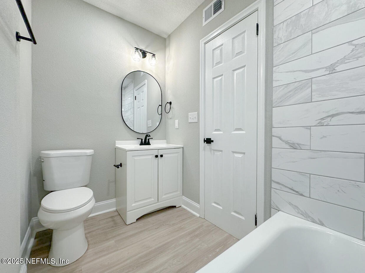 1336 Morgana Road Jacksonville, FL 32211 - Photo 23 of 36 a bathroom with a toilet a sink and a mirror