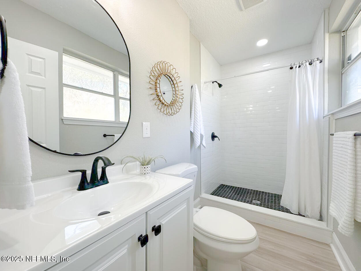 1336 Morgana Road Jacksonville, FL 32211 - Photo 29 of 36 a bathroom with a sink toilet a mirror and shower