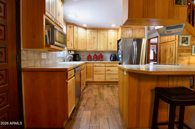 a kitchen with stainless steel appliances a refrigerator and a stove top oven