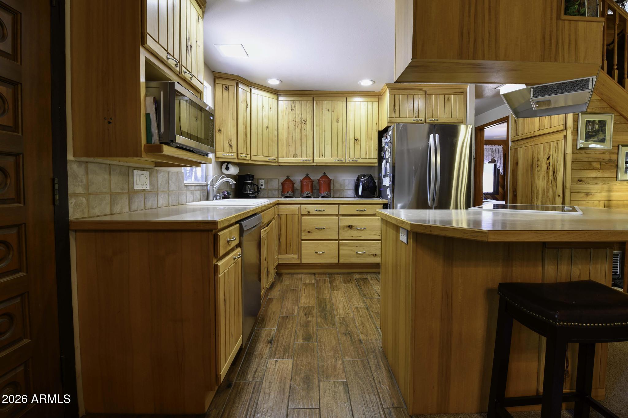 1018 Reata Pass Happy Jack, AZ 86024 - Photo 11 of 33 a kitchen with stainless steel appliances a refrigerator and a stove top oven