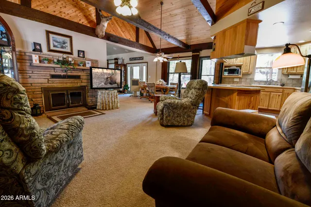 a view of a patio with couches table and chairs under an umbrella