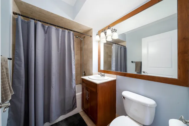 a bathroom with a toilet a sink and mirror