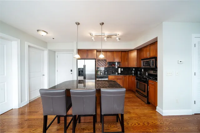 a dining room with furniture a kitchen view and chandelier
