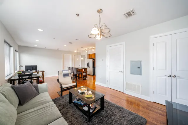 a living room with furniture a dining table and a chandelier