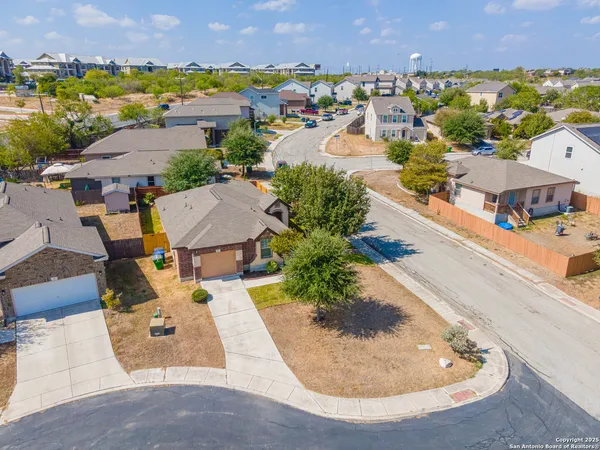 an aerial view of residential houses with outdoor space and parking