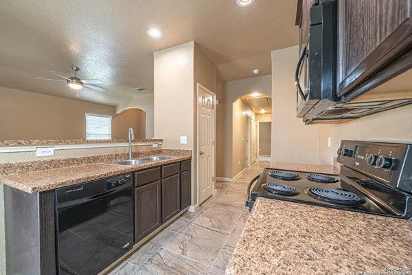 a kitchen with stainless steel appliances granite countertop a sink stove and cabinets