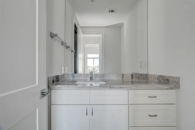 a bathroom with a granite countertop sink and a mirror