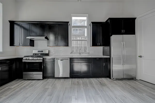 a kitchen with stainless steel appliances granite countertop a stove a refrigerator and a microwave