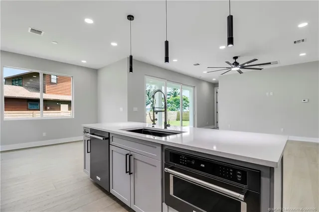an empty room with wooden floor and a ceiling fan