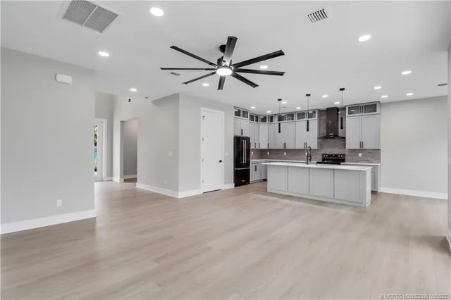 a view of a livingroom with wooden floor and a ceiling fan