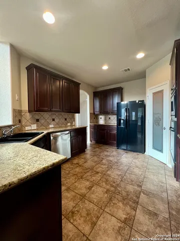 a kitchen with stainless steel appliances granite countertop a refrigerator and a sink