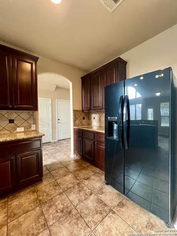 a kitchen with stainless steel appliances granite countertop wooden cabinets a refrigerator and a sink