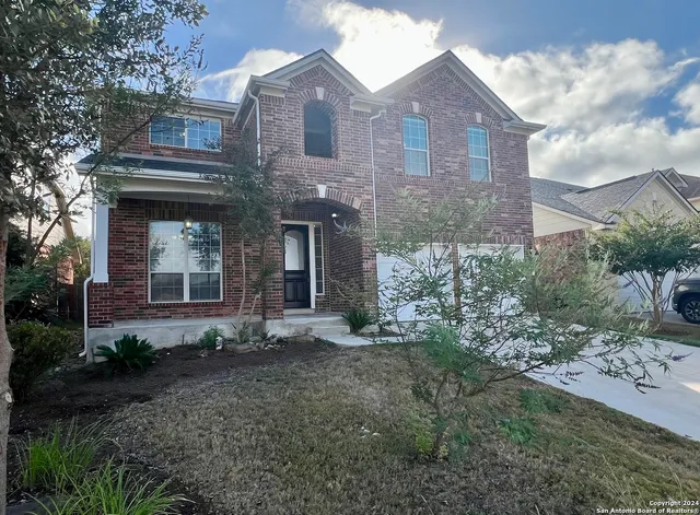 a view of a brick house with large windows and a yard